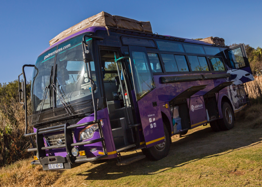 our signature purple G Adventures Lando waits with doors open for overland safari travellers in Africa