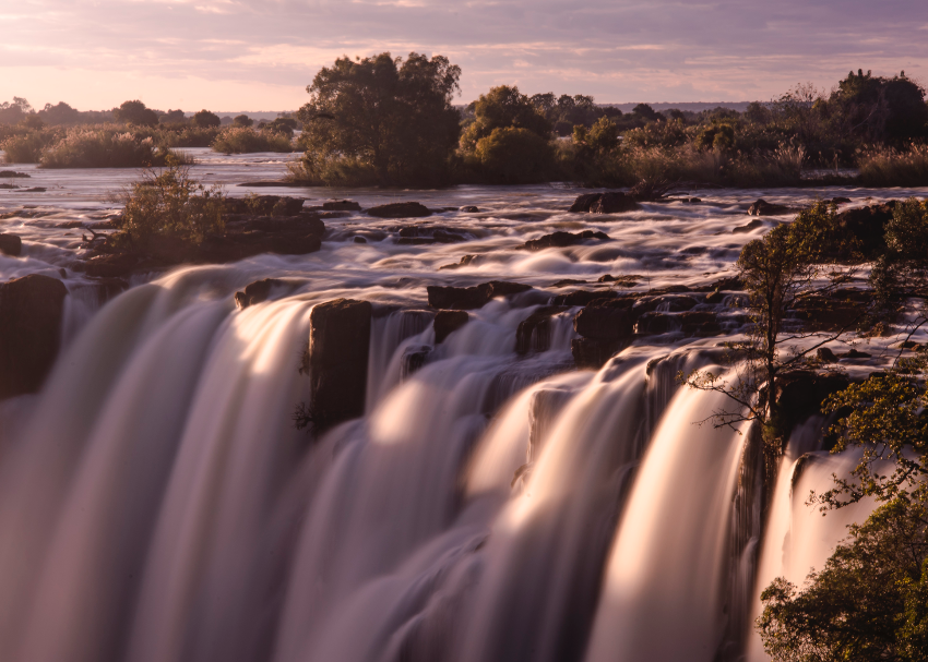 the majestic Victoria Falls in Zimbabwe is frozen by a long exposure photo during a pink sunset