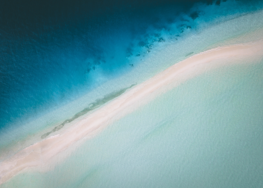 A sand bar lapped by the blue waters of the Maldives